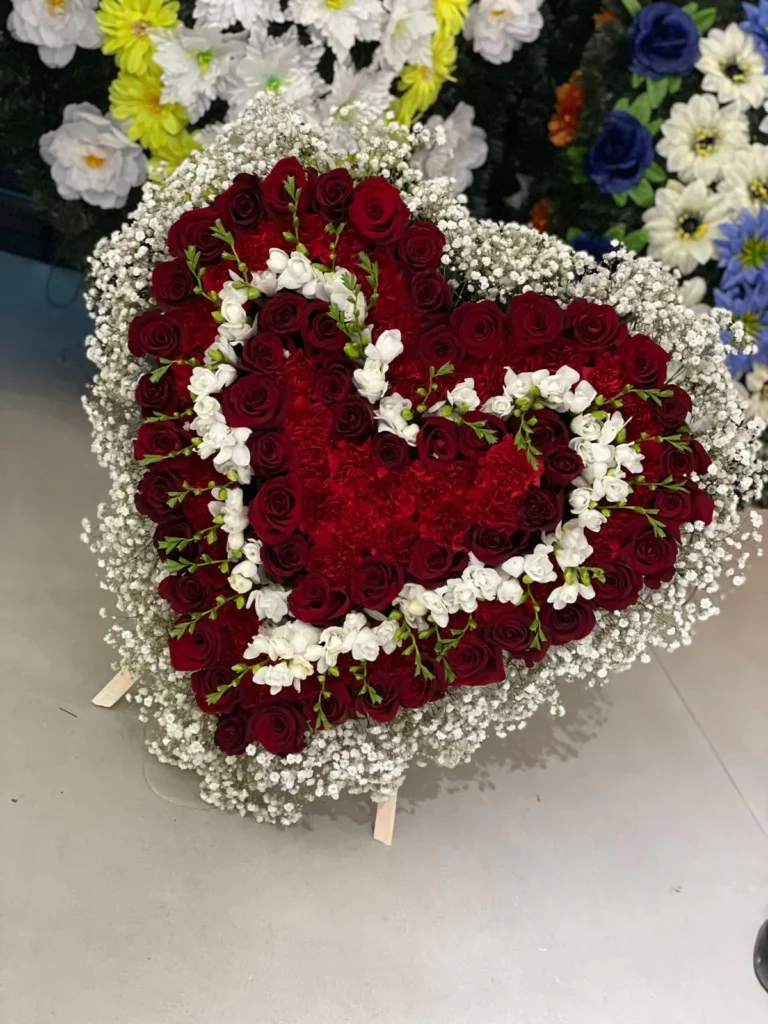 Inimă funerară din trandafiri roșii cu floarea-miresei și frezii albe