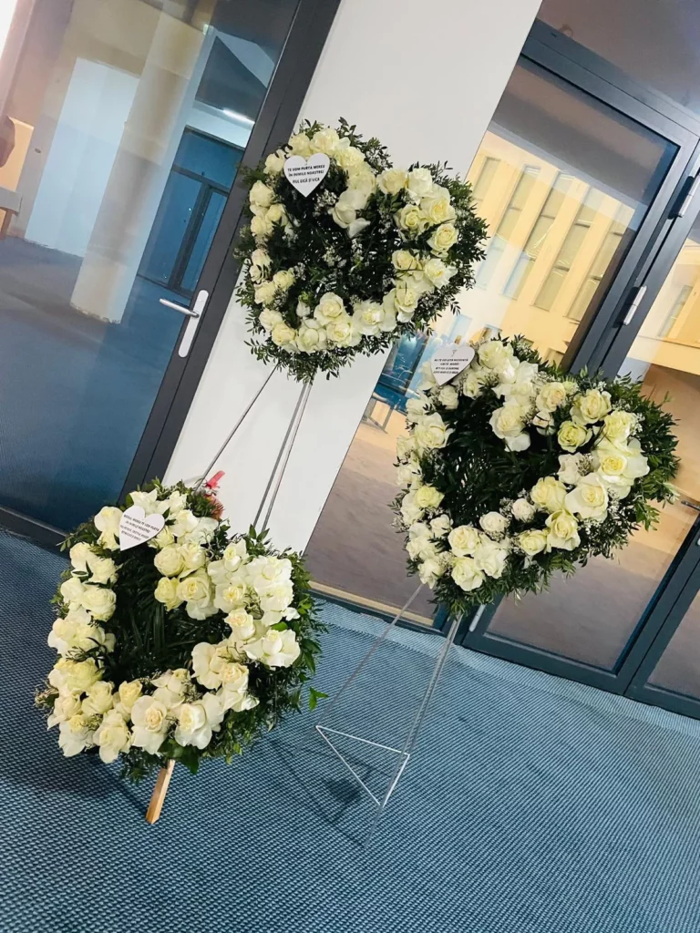 Aranjamente funerare în formă de inimă din trandafiri albi, pe suporturi
